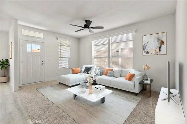 Living Room: Large open living area with updated flooring, recessed lighting, neutral tones, and direct flow to the kitchen and dining spaces.