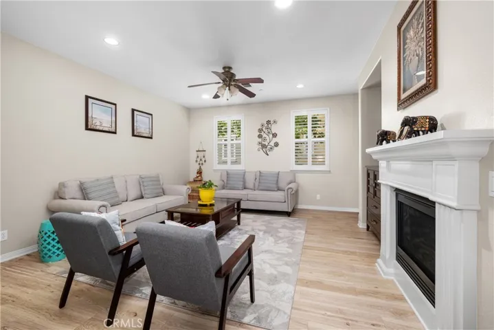 Another view of the Living Room with recessed lighting, Ceiling Fan and cozy Fireplace