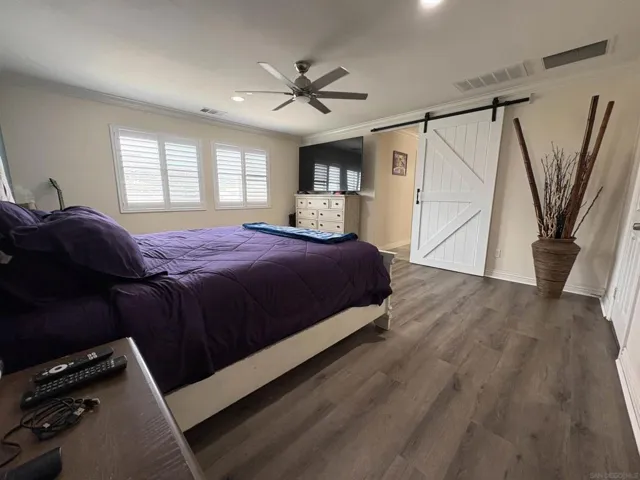 Another angle of the Primary bedroom with a peek towards the primary bathroom. Look at that beautiful barn door!