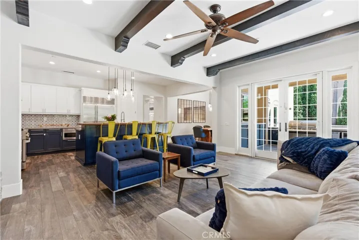 Bright and airy great room with French doors, exposed beam ceilings, designer lighting, and seamless indoor-outdoor California living.