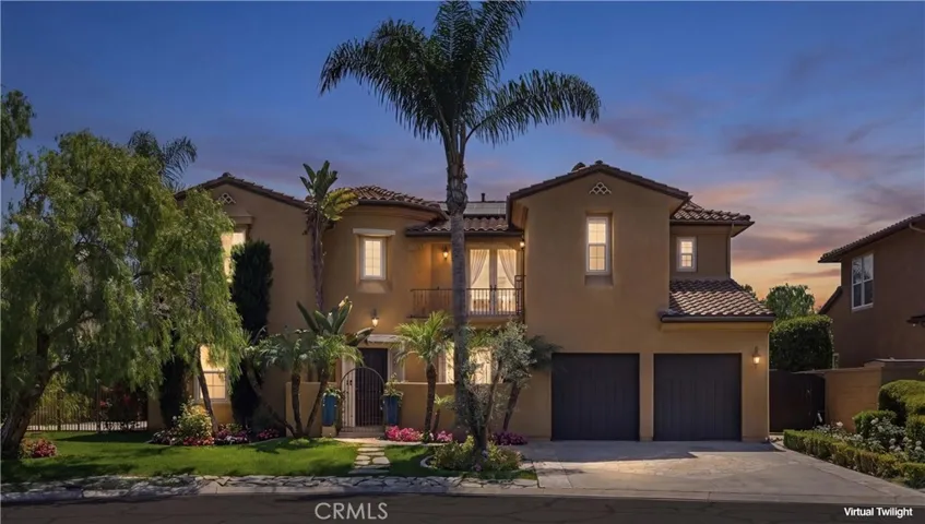Dramatic twilight exterior highlighting the home’s warm ambient lighting, grand curb appeal, and elegant architectural presence within the gated community of Rancho Madrina.