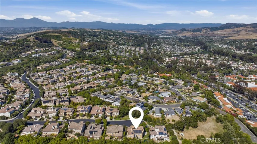 Aerial view showcasing Rancho Madrina’s hillside setting, surrounding neighborhoods, nearby golf course, and scenic mountain backdrop.