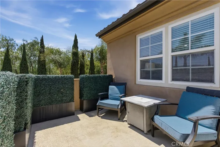 Private balcony off the primary suite overlooking lush mature landscaping with tranquil neighborhood and hillside views.