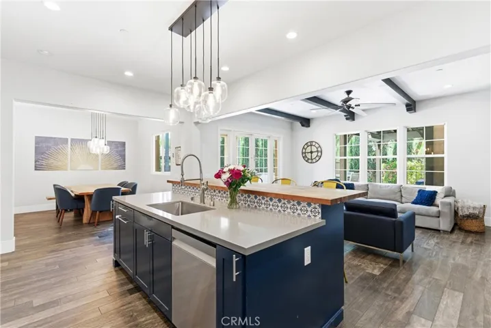 Open-concept kitchen and family room with oversized entertainer’s island, custom cabinetry, stacked-stone fireplace, and designer finishes throughout.