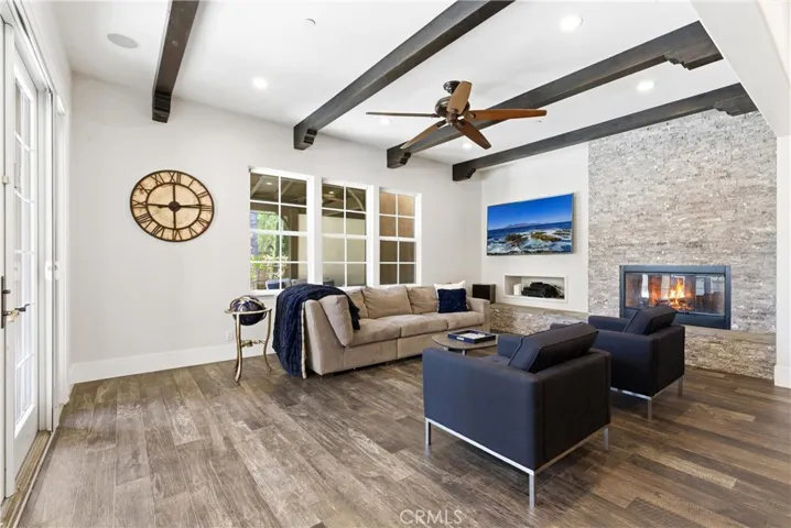 Designer great room featuring exposed wood beams, modern fireplace, custom built-ins, and open flow to the chef’s kitchen and backyard entertaining spaces.