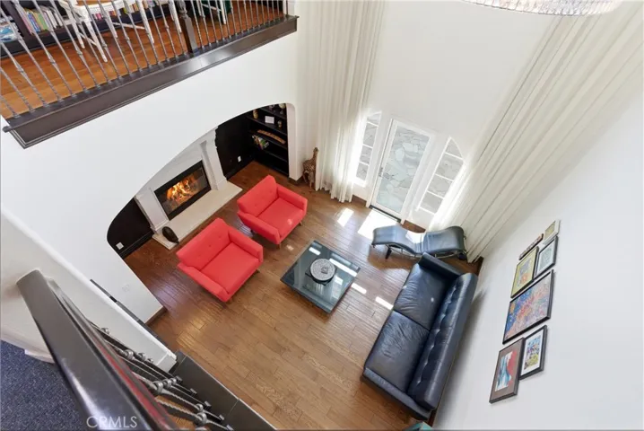 Grand formal living space with soaring ceilings, fireplace, custom built-ins, and floor-to-ceiling windows that flood the home with natural light.