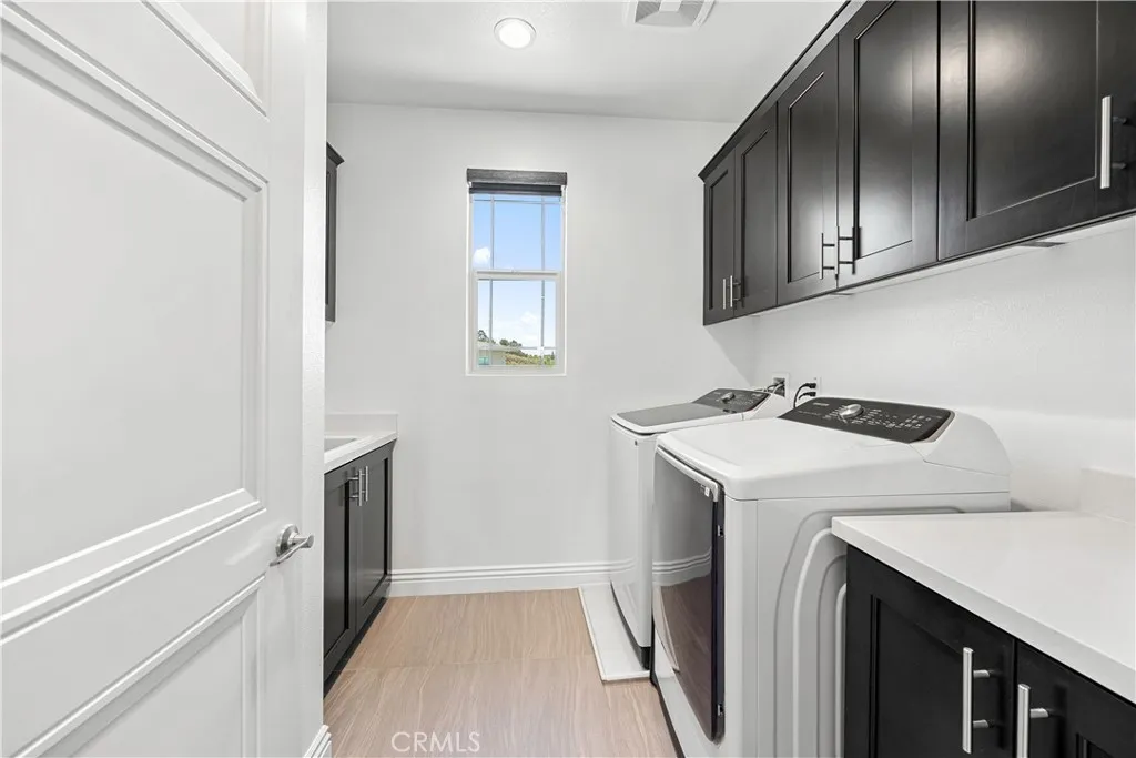 Upstairs laundry with built in cabinetry and utility sink