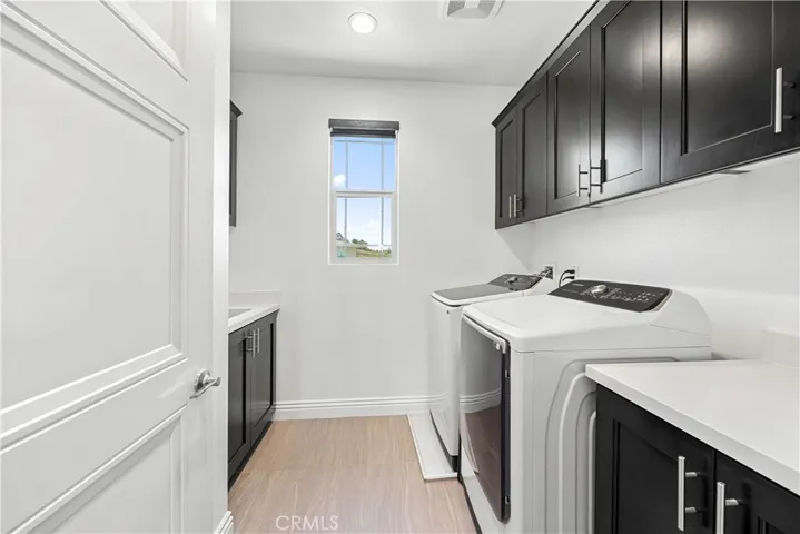 Upstairs laundry with built in cabinetry and utility sink