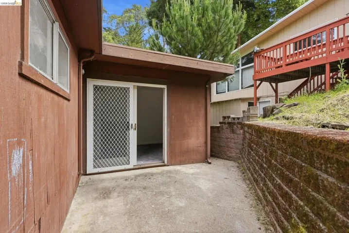 Exterior featuring a concrete patio, sliding glass door with screen, and wood-finish siding