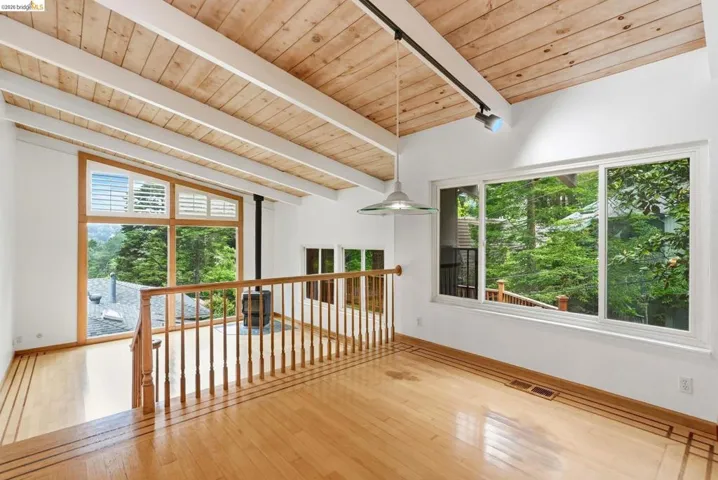 Vaulted wood-plank ceiling with exposed white beams and track lighting