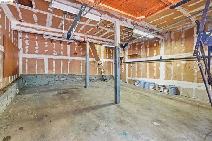 Unfinished garage space with exposed wall studs and concrete flooring