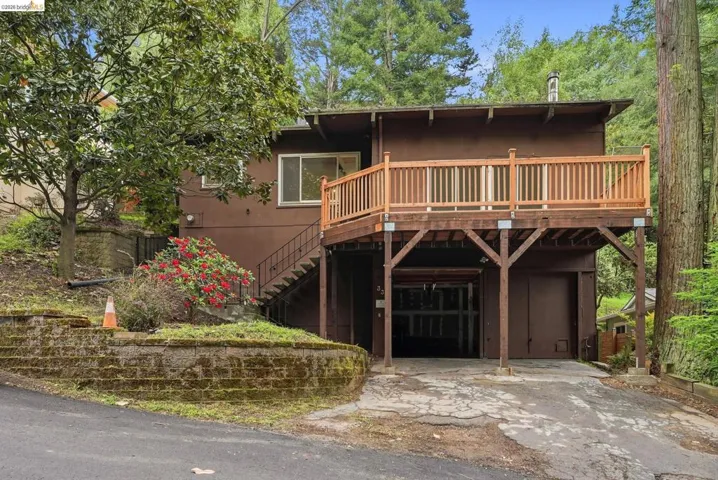 Exterior featuring a second-story wood deck with railing, supported by timber posts