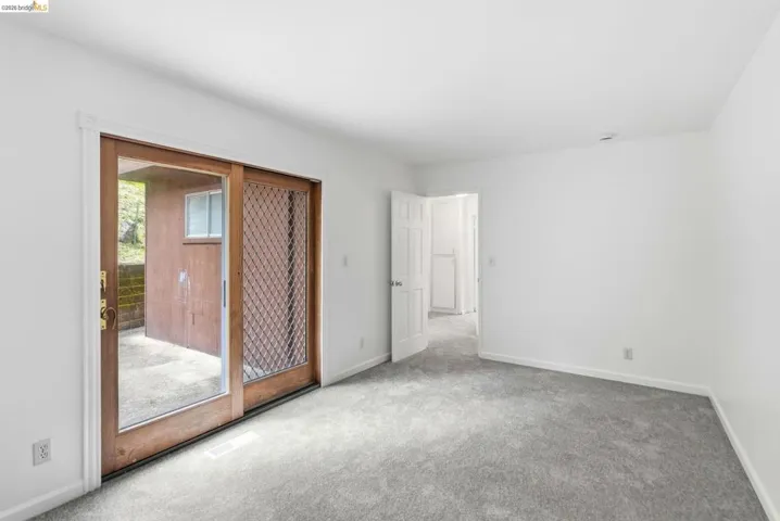 Spacious room featuring light gray carpeting and white painted walls