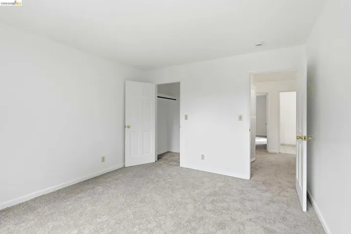 Light gray carpeted room featuring white walls and white trim