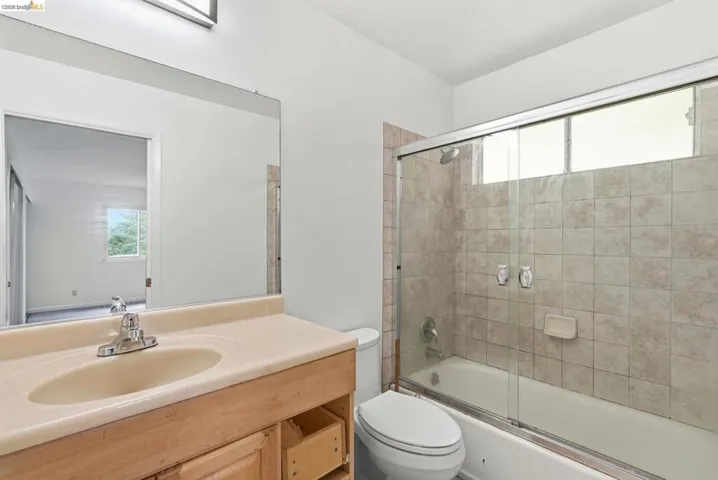 Bathroom featuring a light-toned vanity with an integrated sink and chrome faucet