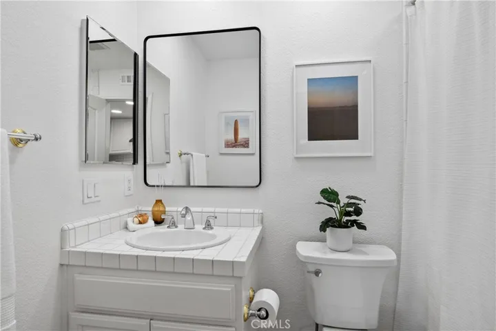 Located just outside the secondary bedroom, the secondary bath is thoughtfully positioned to serve as a private and convenient guest bathroom.