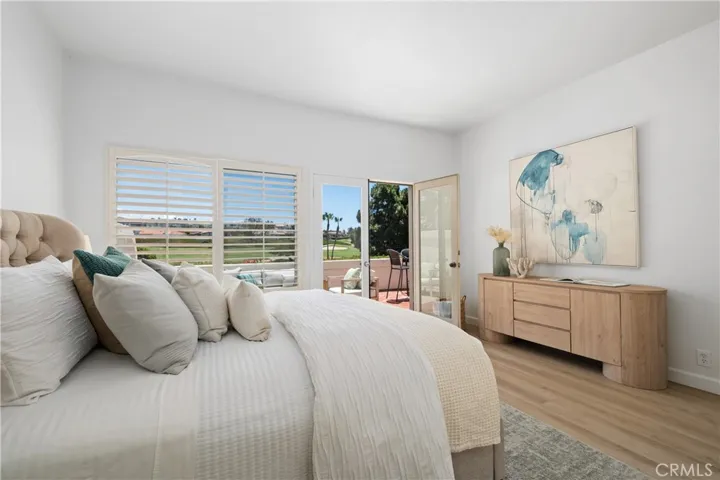 The generously sized primary suite features elegant French doors leading to the private patio, offering a tranquil escape and easy access to outdoor living.