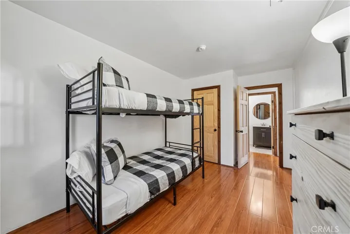 Guest sleeping area with bunk beds, storage, and nearby bathroom access.