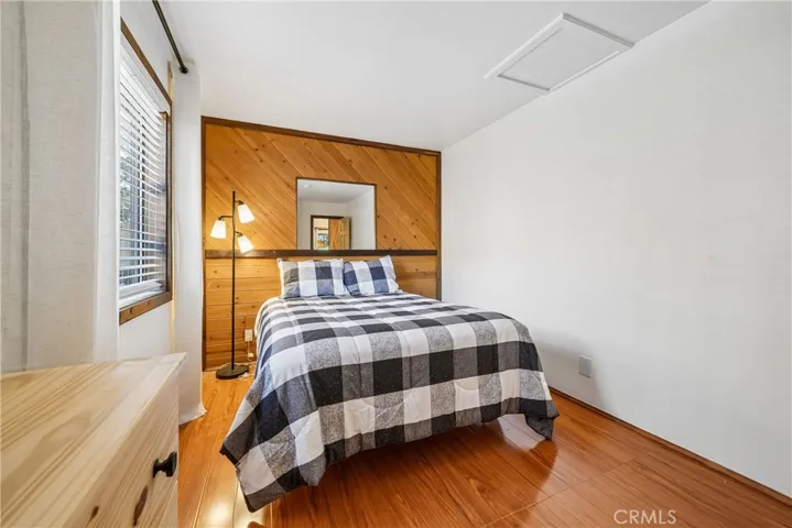 Bedroom view showing natural light, wood trim, and efficient layout.