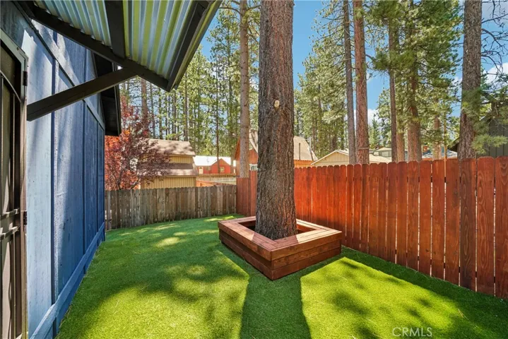 Private fenced backyard with low-maintenance turf and outdoor gathering space.