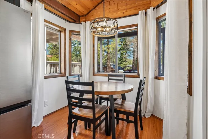 Dining nook surrounded by windows with natural light and mountain neighborhood views.
