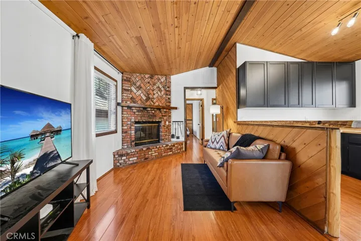 Living area with warm wood accents, brick fireplace, and generous natural light.