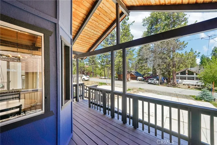 Covered front porch overlooking the neighborhood and level parking area.