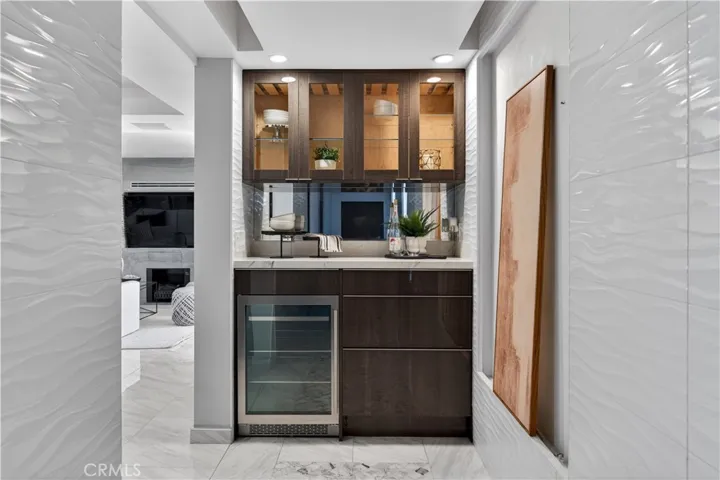 Pretty bar and wine fridge sit at the end of the entry way.