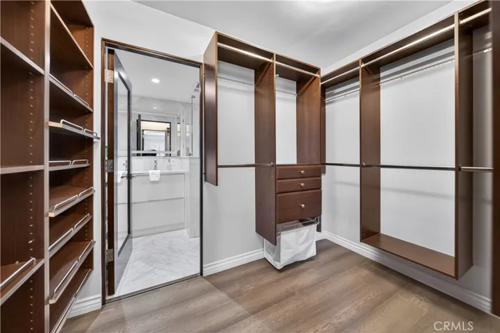 Walk-in closet also includes shoe racks and leads to the primary bathroom.