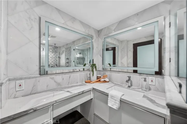 Vanity area with counter and storage space plus dual mirrors.