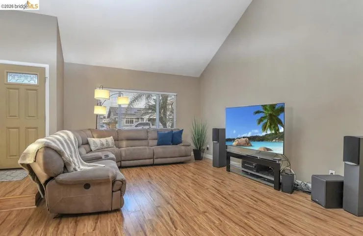 Living area with high vaulted ceiling and light wood-style floors
