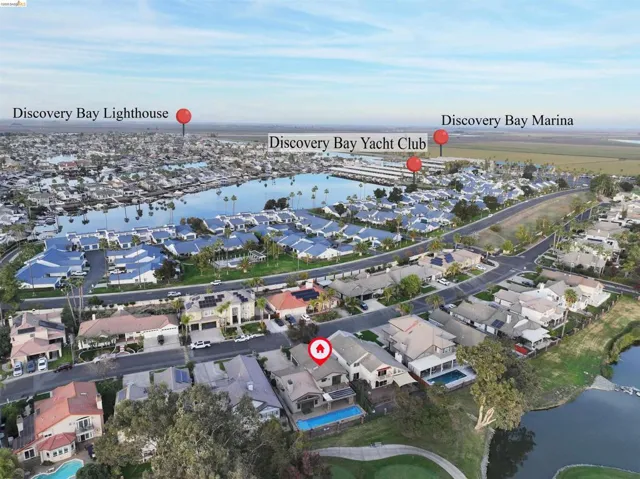 Aerial overview of property's location featuring a nearby body of water and nearby suburban area