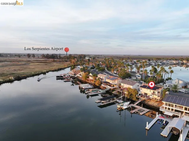 Aerial perspective of suburban area featuring a nearby body of water