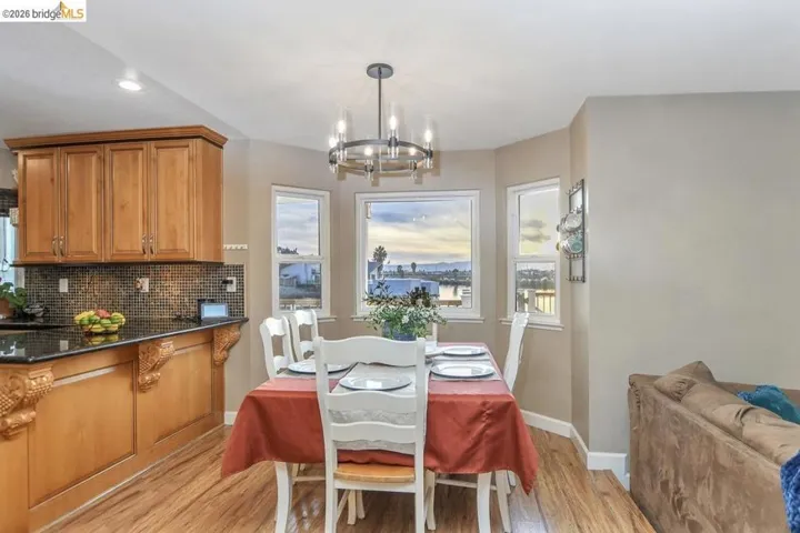 Dining space featuring healthy amount of natural light, light wood-style flooring, a chandelier, and recessed lighting