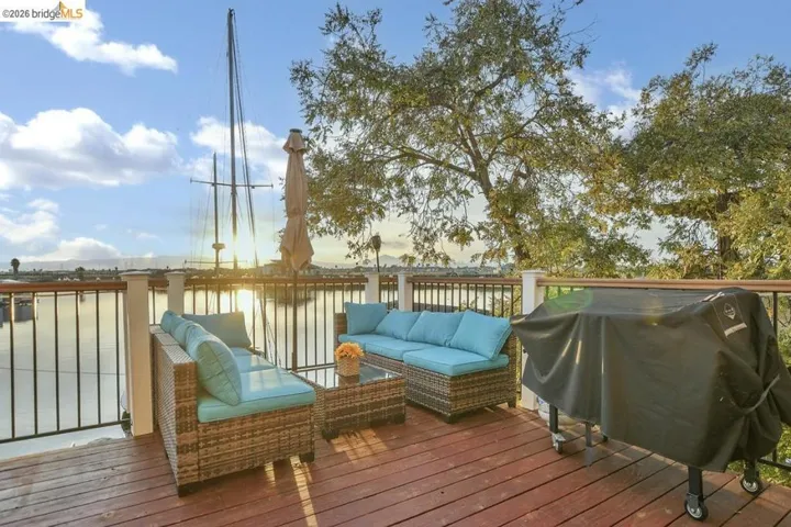 Wooden terrace featuring area for grilling, a water view, and outdoor lounge area