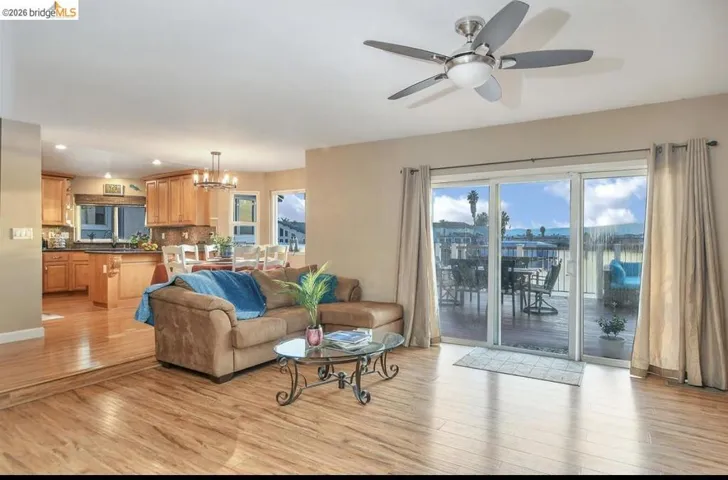 Living room with light wood-type flooring, a chandelier, a ceiling fan, and recessed lighting