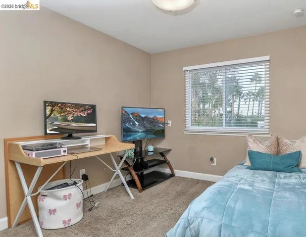 Bedroom featuring light colored carpet and baseboards