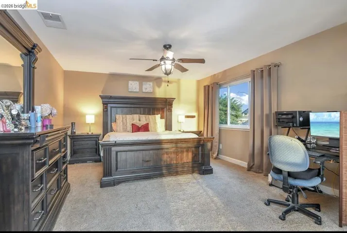 Bedroom with light carpet and a ceiling fan