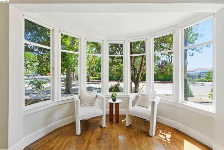 Curved bay window offering expansive exterior views, featuring multiple individual window panels and wood-finish flooring