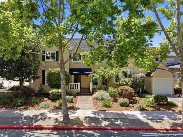 Two-story residence featuring a stucco exterior and dark window shutters