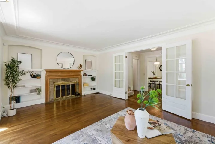 Hardwood flooring throughout a spacious room featuring a wood fireplace with a tiled surround