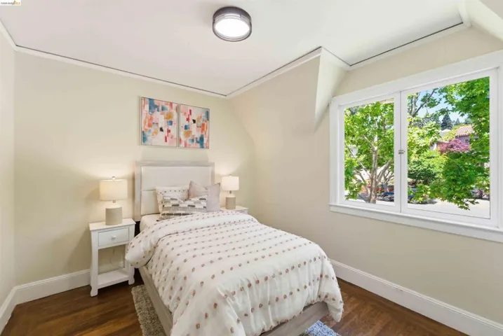 Room featuring wood-finish flooring, a double window with white trim, and a contemporary flush-mount ceiling light