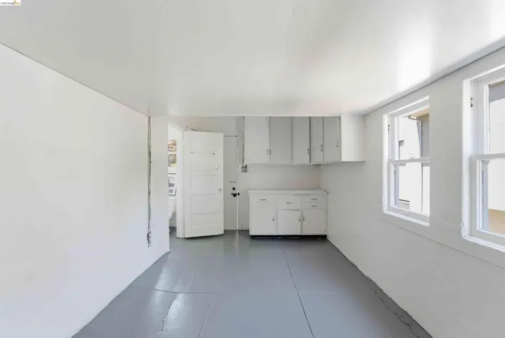 Room with light gray flooring, white walls, and two single-hung windows