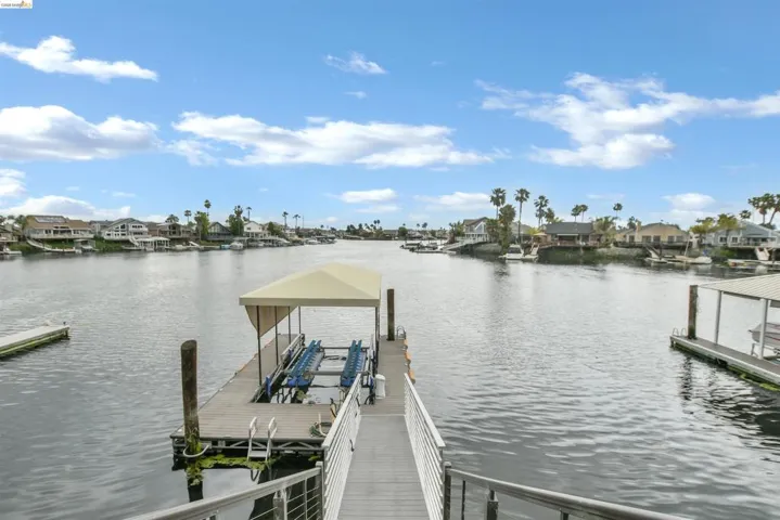 Private dock featuring a covered boat lift, gangway access, and water frontage