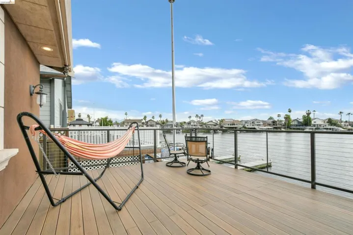 Exterior deck featuring wood-finish flooring, cable railing, and recessed lighting