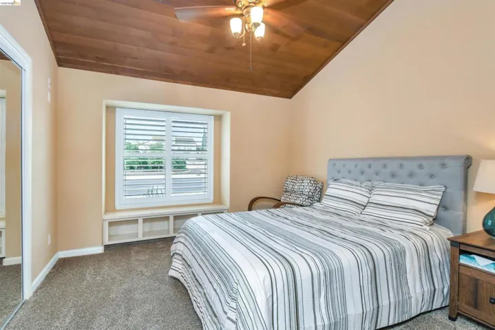 Vaulted wood-paneled ceiling with a ceiling fan
