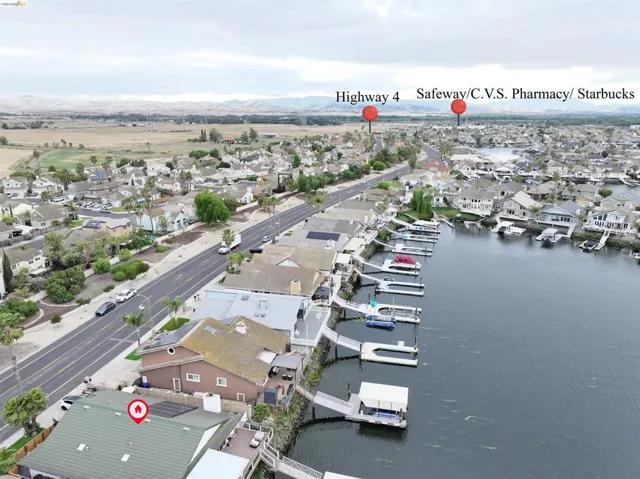 Waterside property featuring a green-hued roof, solar panels, and an extensive dock system