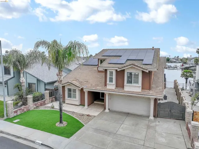 Two-story residence featuring a tile roof and solar panels