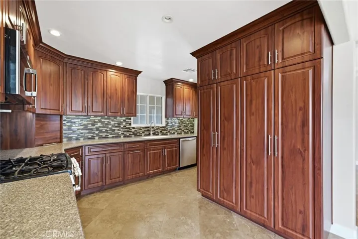 Kitchen features roll-out pantry shelves and excellent cabinet storage.