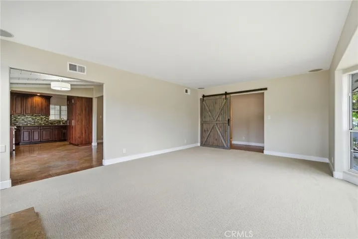 Barn door detail offers flexibility and separation within the living space.